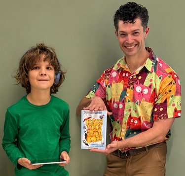 Chip Colquhoun and Noah Shaw stand together with a copy of The Bestest Story In The World... Ever!