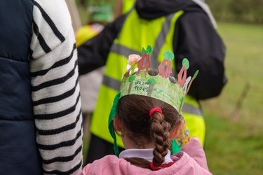 A child wears a paper crown to celebrate Arbor Day.