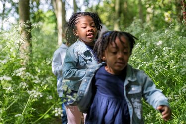Children playing and running through the woods.