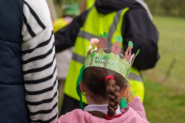 A child wears a paper crown to celebrate Arbor Day.