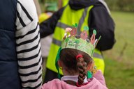 A child wears a paper crown to celebrate Arbor Day.